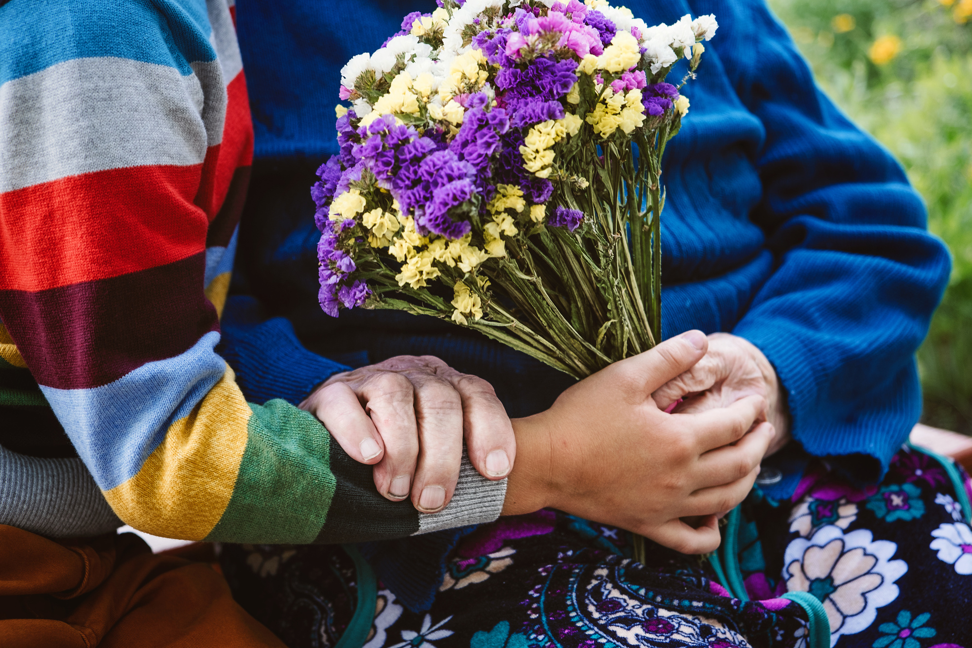 People Holding Hands with Colorful Flowers 